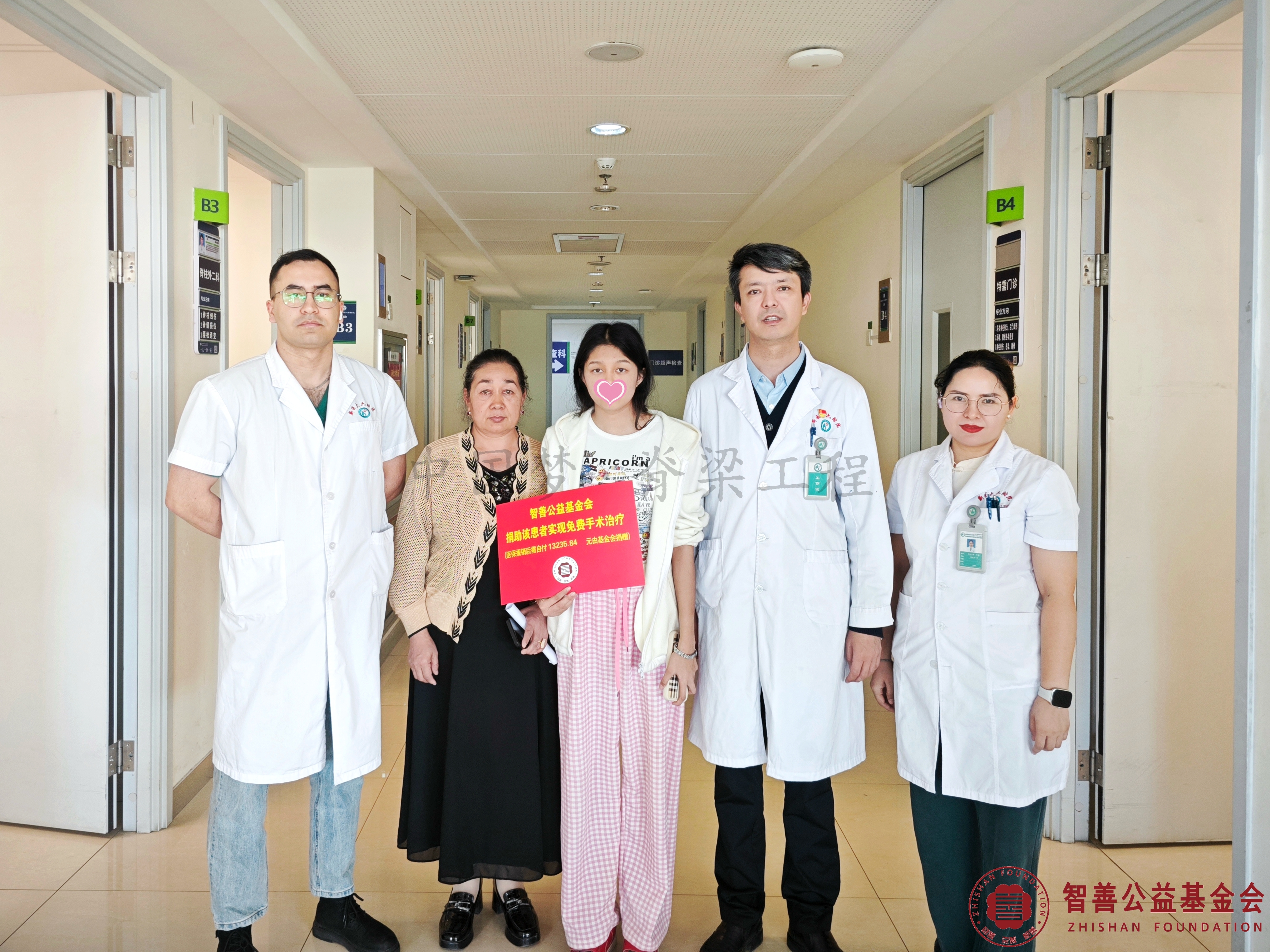 13新疆医科大学第六附属医院阿不都乃比·艾力主任（右二）和医生（左起）尔帕尼江、阿吉古丽将智善公益基金会捐赠的13235.84元转交给新疆喀什市患者努尔比耶穆（该患者实现免费治疗）.jpg