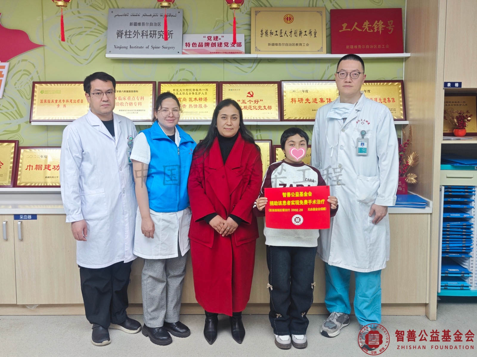 25新疆医科大学第六附属医院医生（左起）买买提艾力、阿吉古丽、李栎将智善公益基金会捐赠的3992.28元转交给患者阿吉合尼穆（该患者实现免费治疗）.jpg