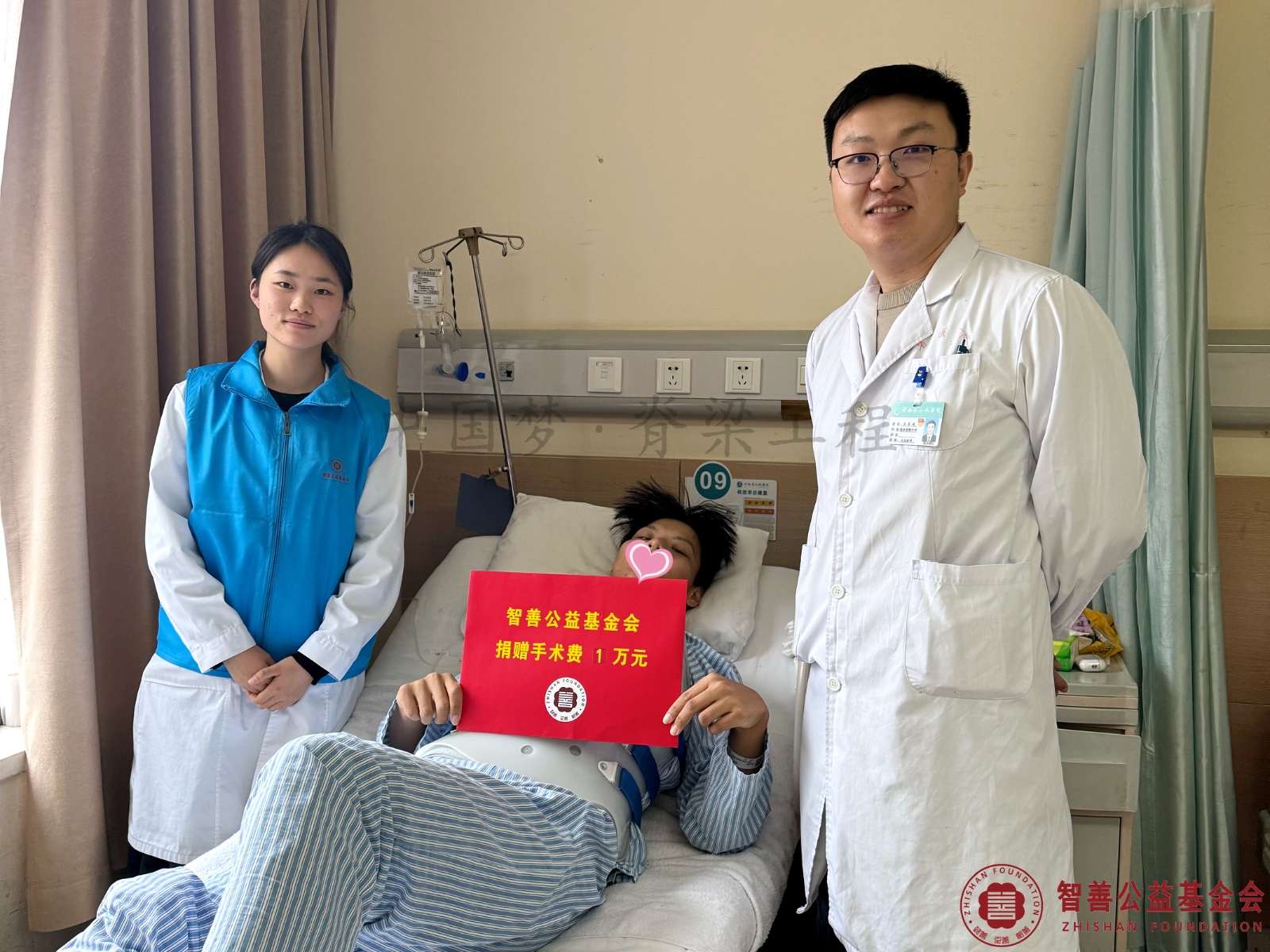 45河南省人民医院爱心志愿者夏梦洁（左一）、吕东波医生将智善公益基金会捐赠的1万元转交给河南南阳卧龙区患者郑博文.jpg