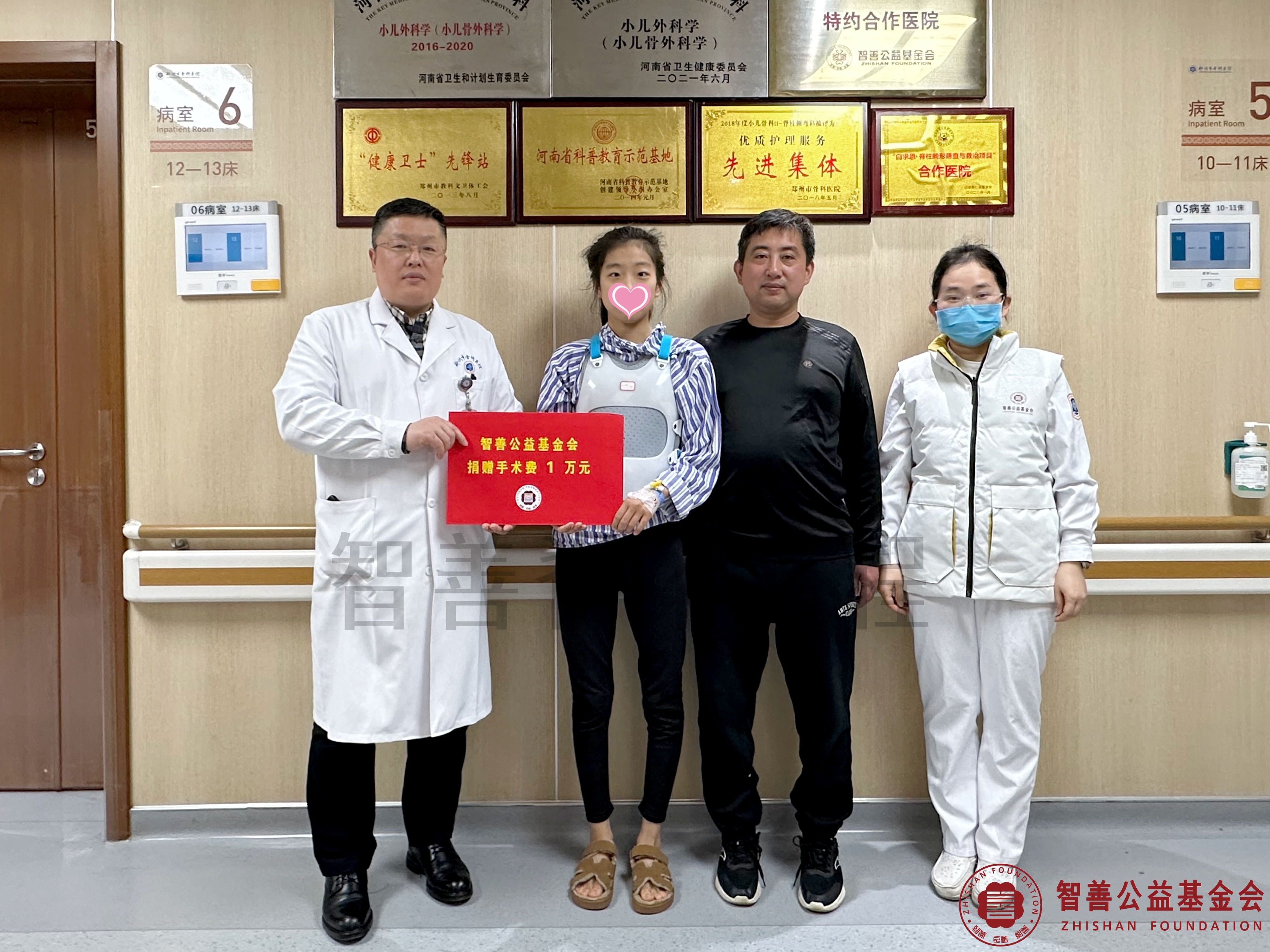 4郑州市骨科医院马鸿杰副主任医师（左一）、爱心志愿者孙静娜将智善公益基金会捐赠的1万元转交给河南周口商水县患者小王.jpg