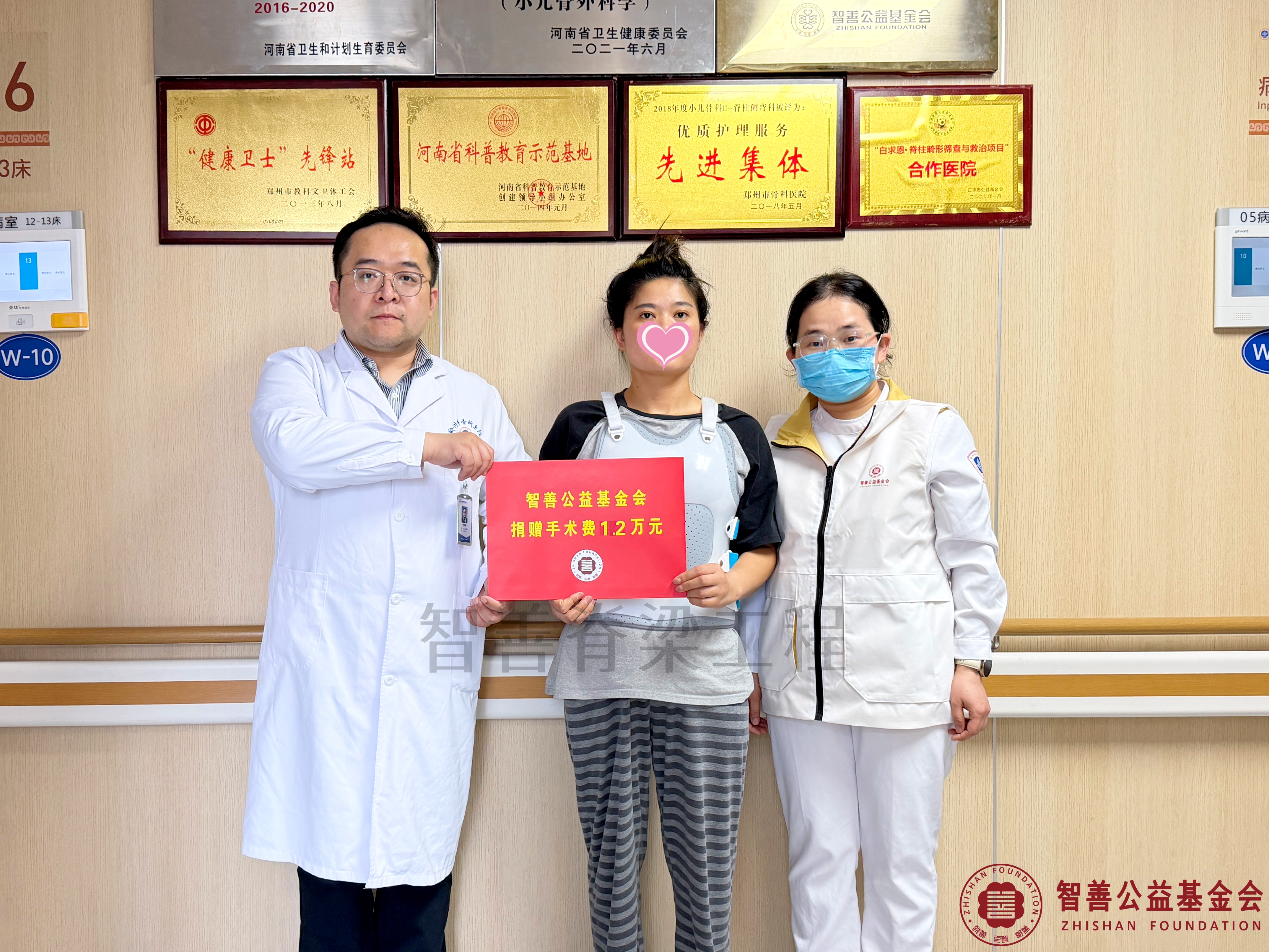 46郑州市骨科医院（左起）刘少峥医生、爱心志愿者孙静娜将智善公益基金会捐赠的1.2万元转交给安徽阜阳太和县患者小王.jpg