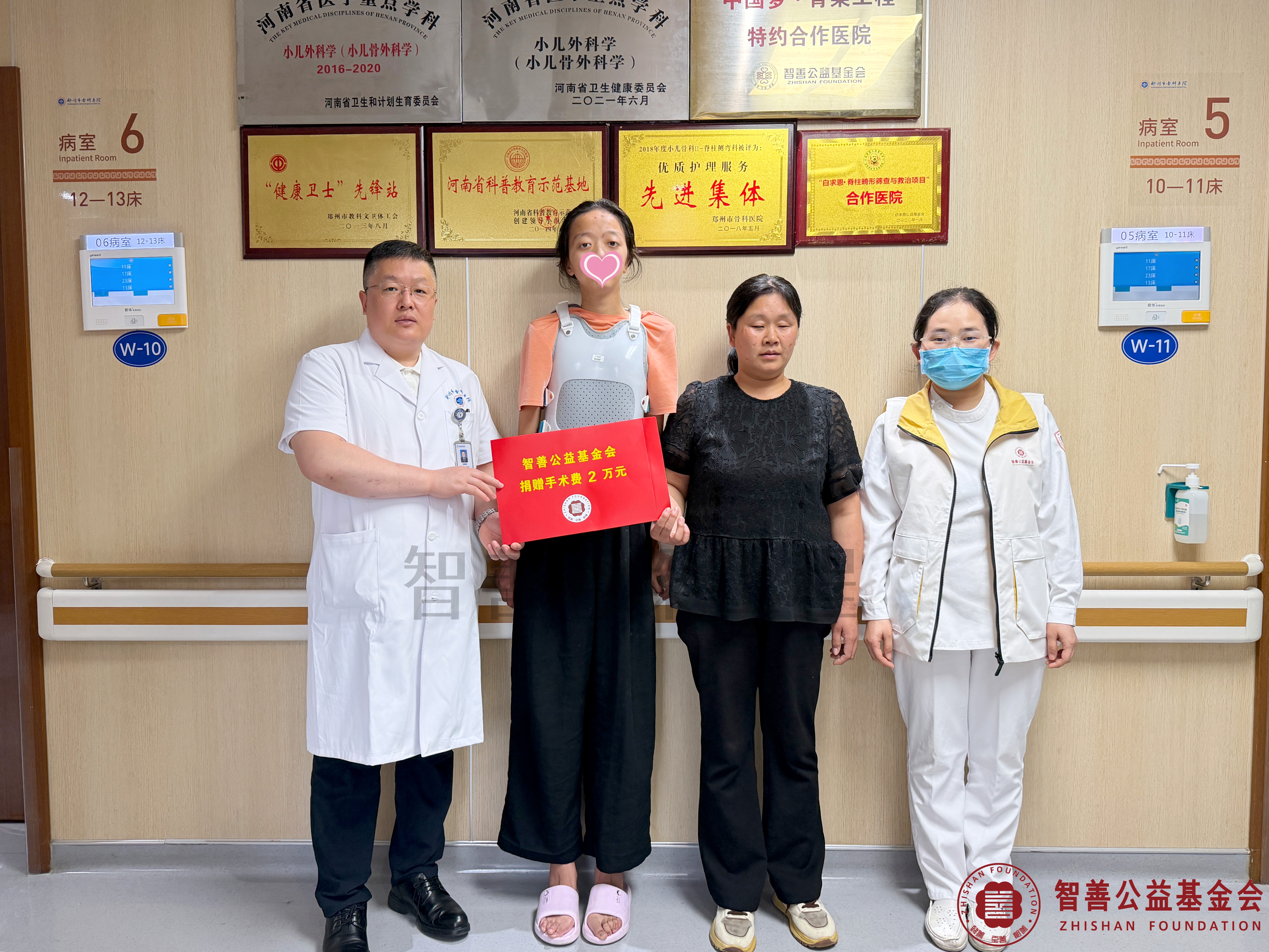 34郑州市骨科医院马鸿杰副主任医师（左一）、爱心志愿者孙静娜将智善公益基金会捐赠的2万元转交给河南南阳桐柏县患者党银雪.jpg