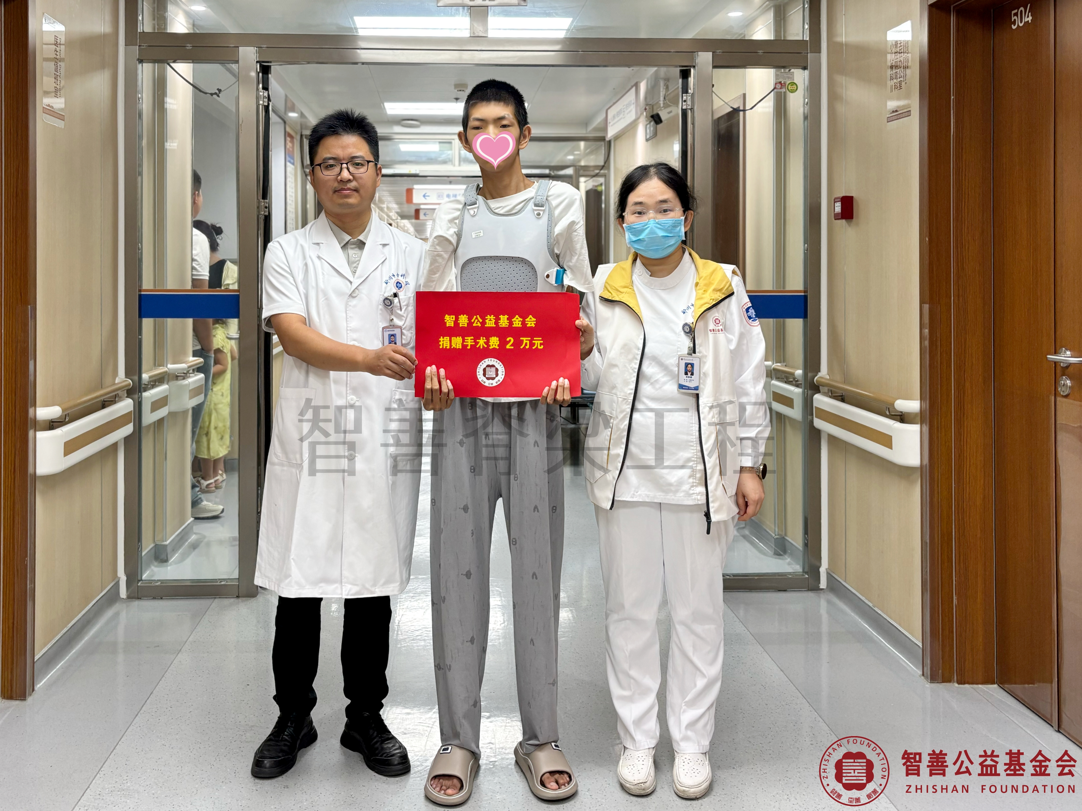 43郑州市骨科医院朱峰医生（左一）、爱心志愿者孙静娜将智善公益基金会捐赠的2万元转交给河南安阳龙安区患者王政浩.jpg