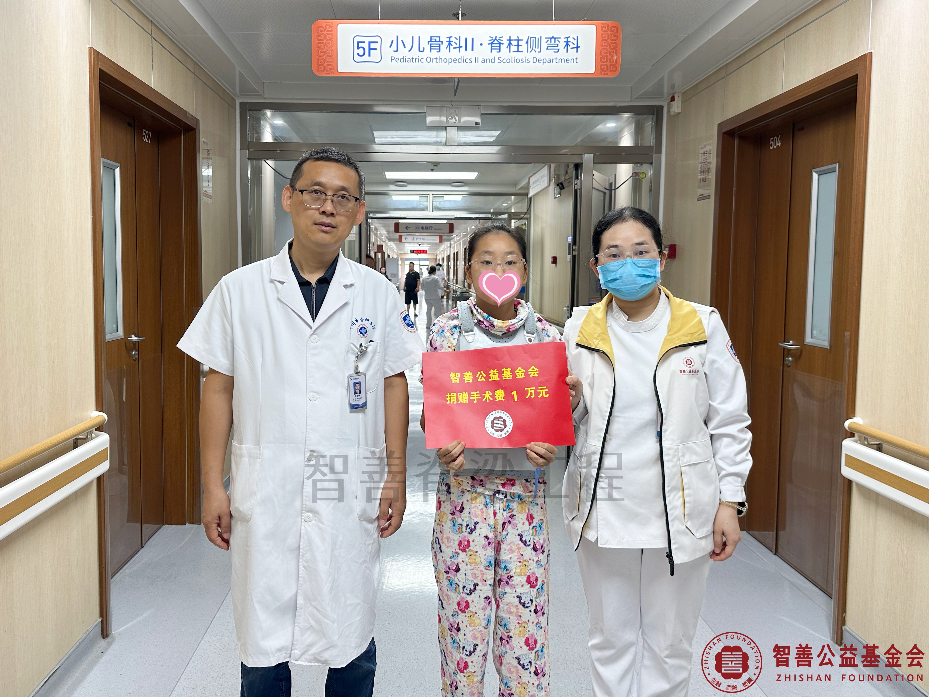 42郑州市骨科医院（左起）孙占辉医生、爱心志愿者孙静娜将智善公益基金会捐赠的1万元转交给河南焦作温县患者靳以帆.jpg