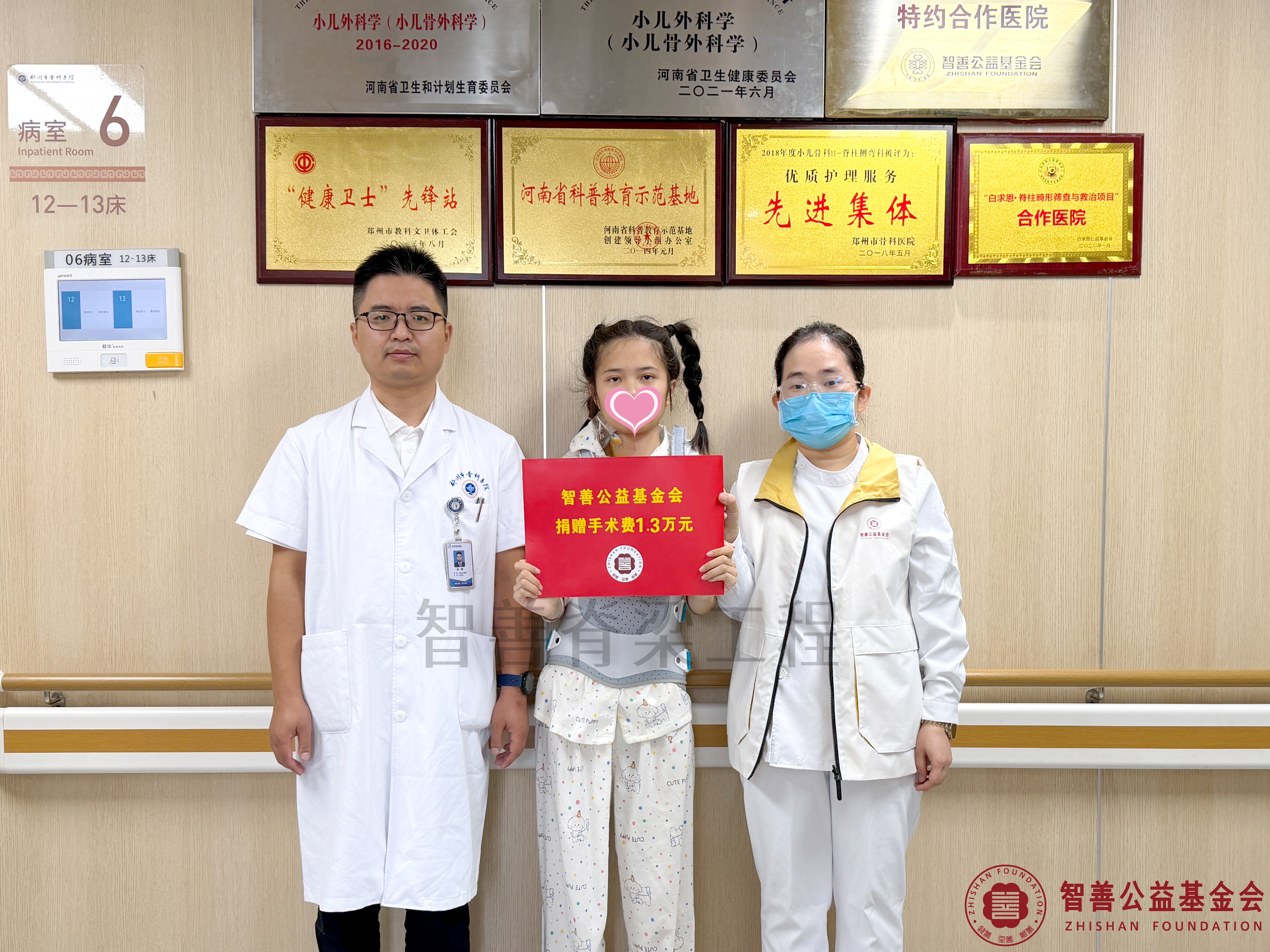 58郑州市骨科医院（左起）朱峰医生、爱心志愿者孙静娜将智善公益基金会捐赠的1.3万元转交给河南周口扶沟县患者张舒涵.jpg