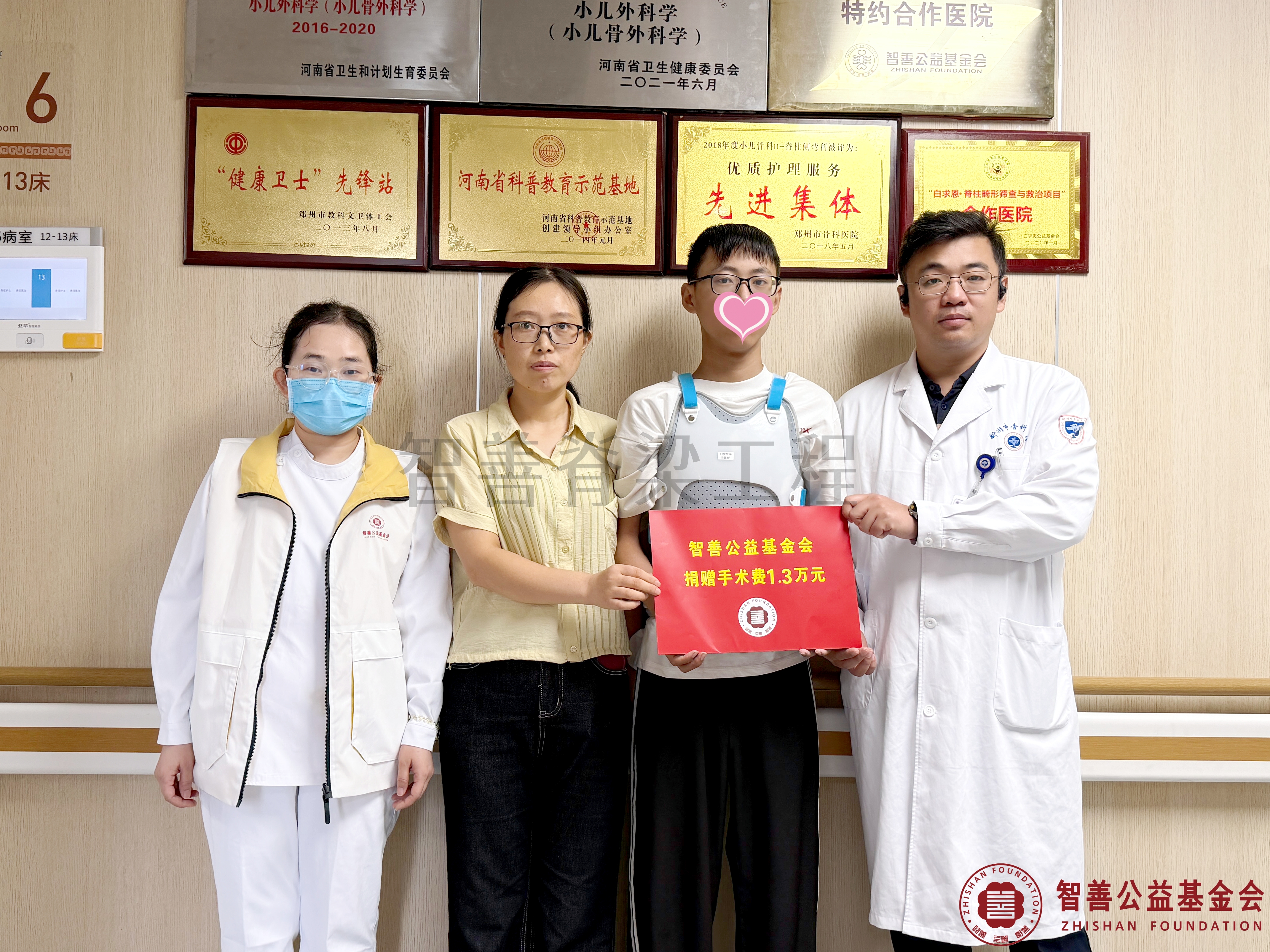 70郑州市骨科医院（左起）爱心志愿者孙静娜、卢坤医生将智善公益基金会捐赠的1.3万元转交给河南焦作温县患者马浩恩.jpg