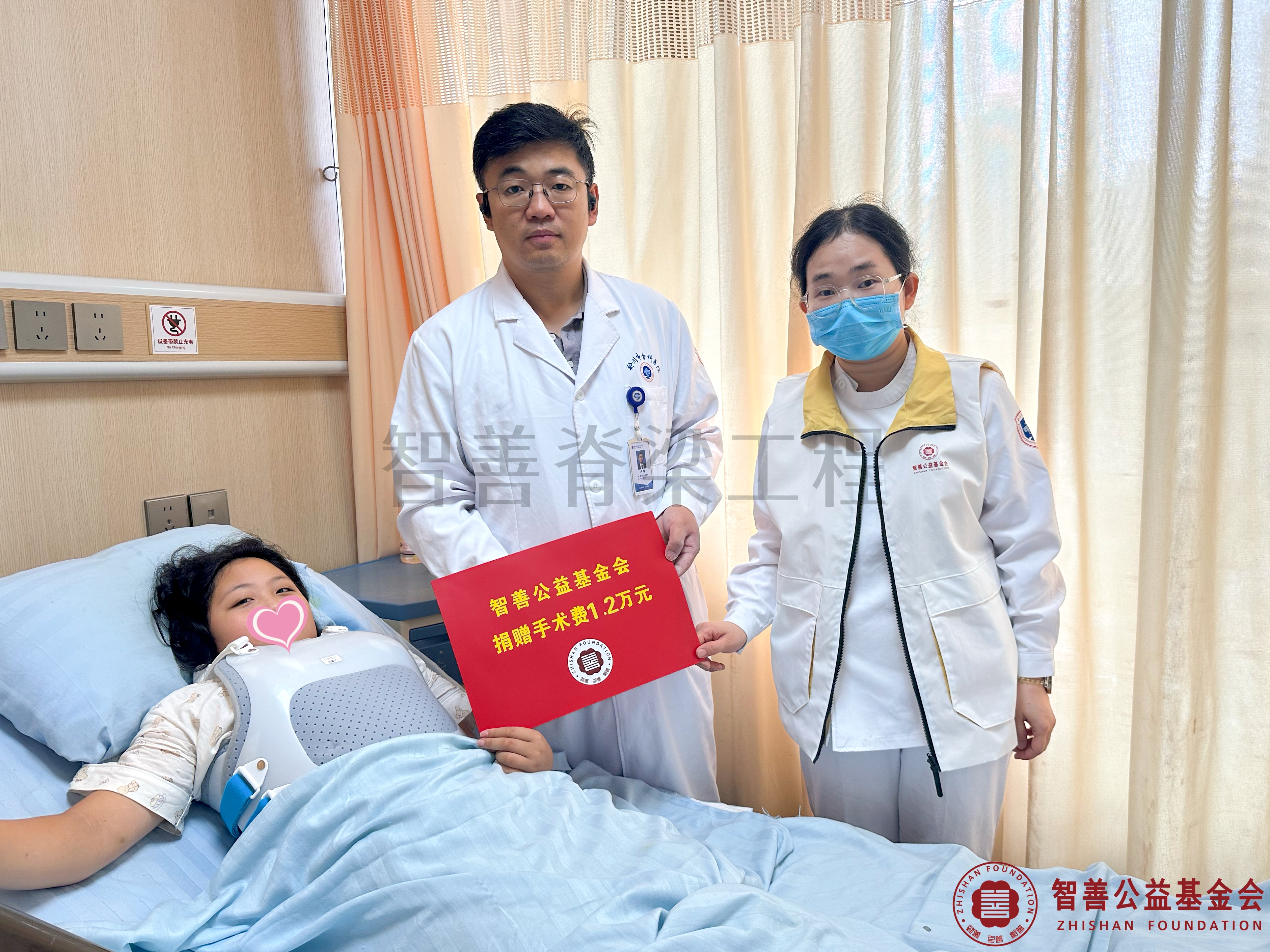 122郑州市骨科医院（左起）卢坤医生、爱心志愿者孙静娜将智善公益基金会捐赠的1.2万元转交给河南南阳新野县患者刘馨忆.jpg