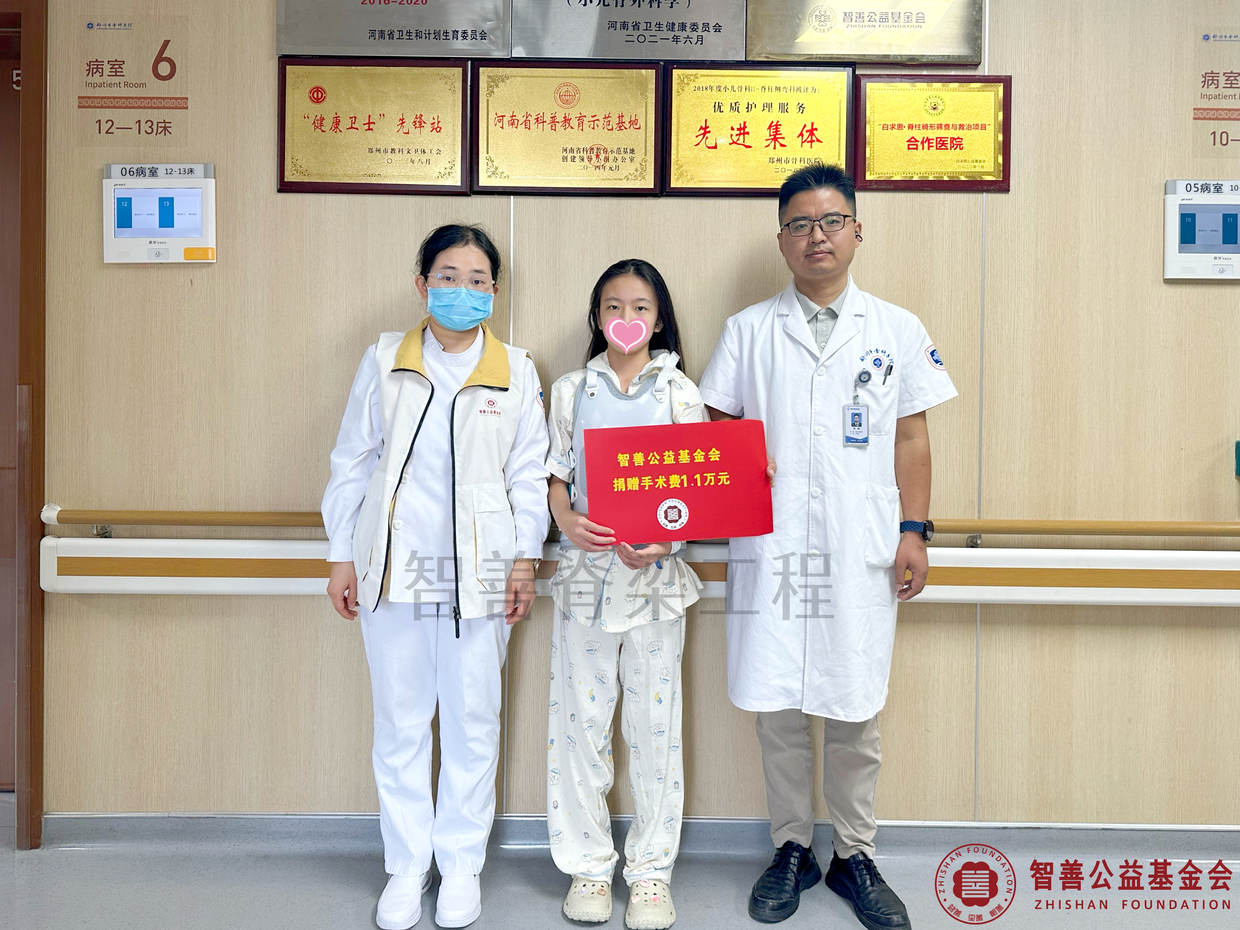 130郑州市骨科医院（左起）爱心志愿者孙静娜、朱峰医生将智善公益基金会捐赠的1.1万元转交给河南南阳社旗县患者吴紫瑶.jpg