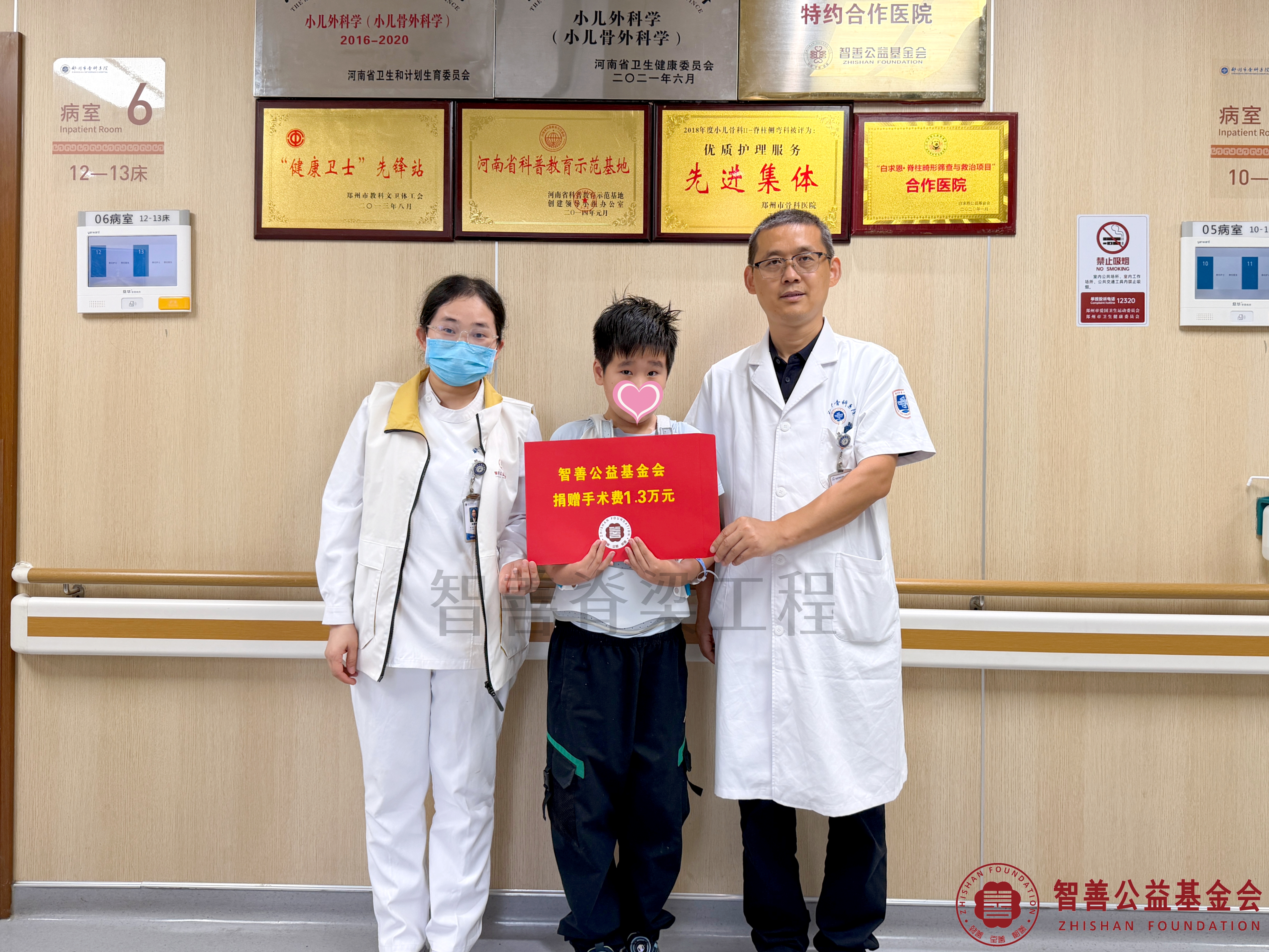 60郑州市骨科医院（左起）爱心志愿者孙静娜、孙占辉医生将智善公益基金会捐赠的1.3万元转交给河南郑州金水区患者杨景涵.jpg