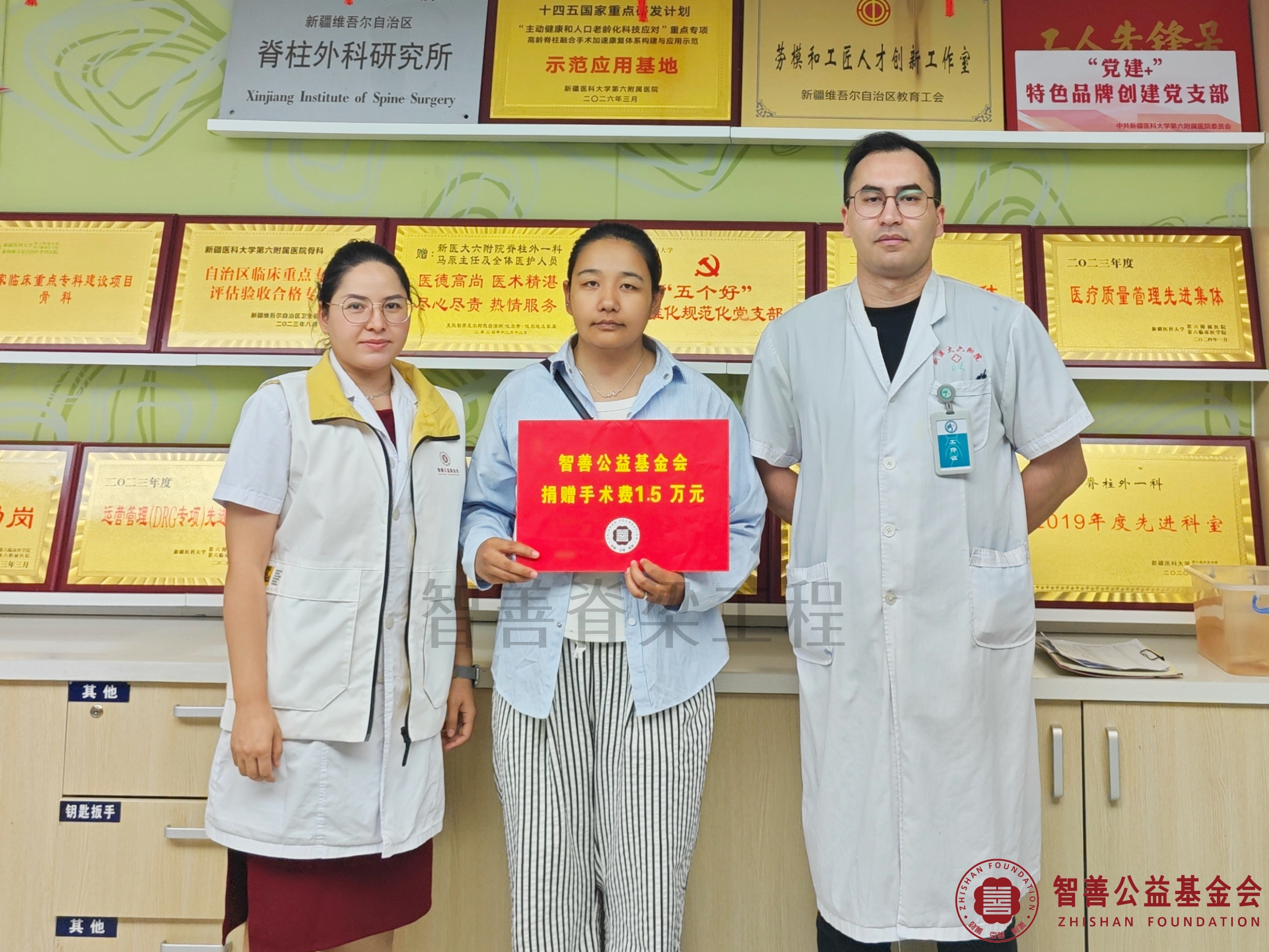 93新疆医科大学第六附属医院（左起）爱心志愿者阿吉古丽、尔帕尼江医生将智善公益基金会捐赠的1.5万元转交给新疆哈密地区哈密市患者古丽苏姆（其姐姐代领）.jpg