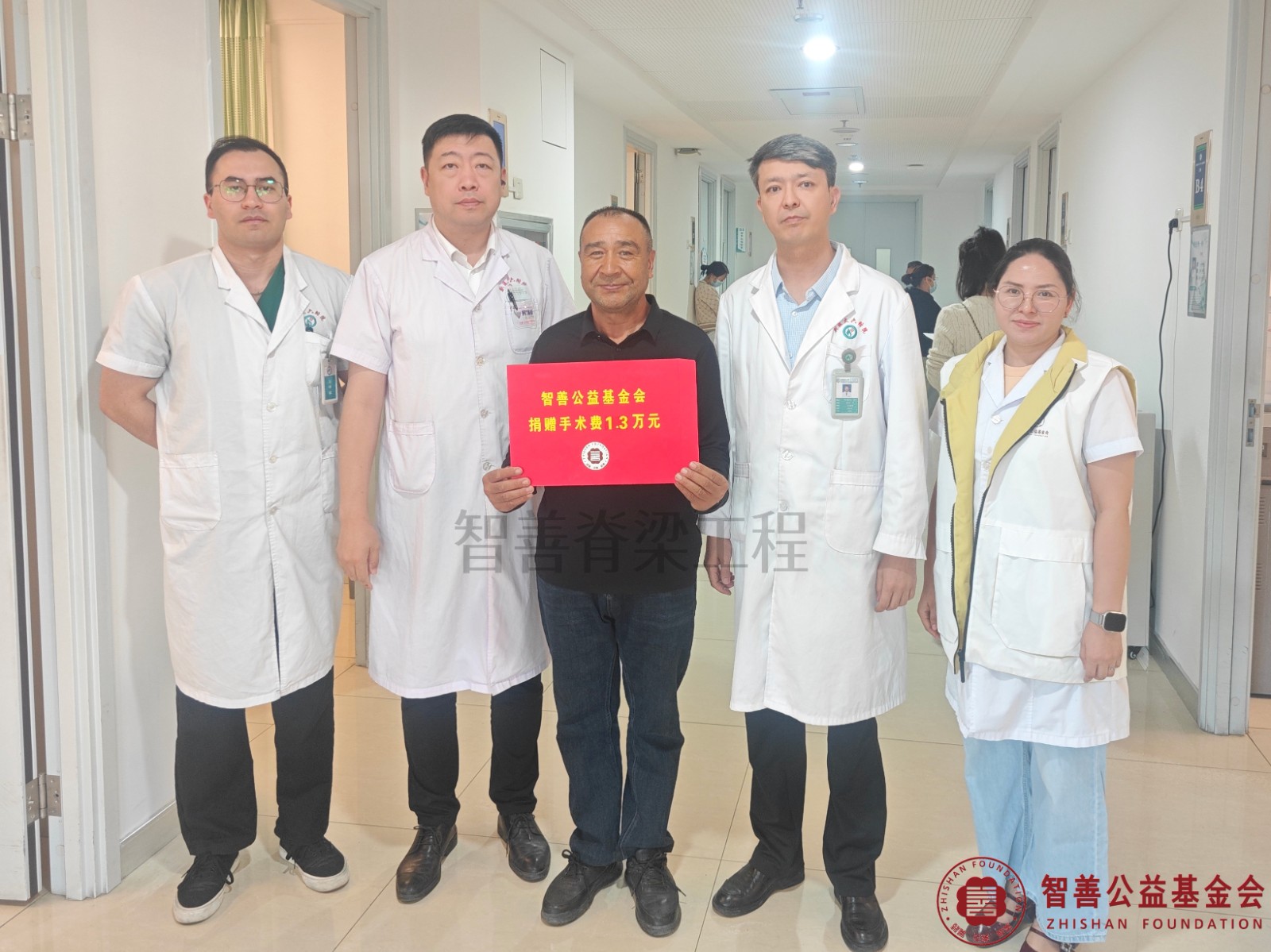 67新疆医科大学第六附属医院阿不都乃比·艾力主任（右二）、尔帕尼江医生（左一）、任政医生（左二）、爱心志愿者阿吉古丽医生将智善公益基金会捐赠的1.3万元转交给新疆喀什地区喀什市患者努尔孜巴（其父亲代领）.jpg