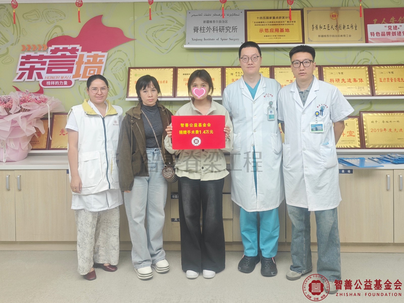 50新疆医科大学第六附属医院李栎医生（右二）、卡马力别克医生（右一）和爱心志愿者阿吉古丽医生将智善公益基金会捐赠的1.4万元转交给新疆吐鲁番地区 吐鲁番市患者热依拉.jpg